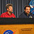 In this image, Jim Graf (Mars Reconnaissance Orbiter project manager) is seated on the left at a long, wooden table bearing the circular red, white and blue NASA 'meatball' logo.  He is wearing a long-sleeved red, button-up shirt and answering a question from a reporter.  He is a middle-aged Caucasian man with brown hair, a goatee and a light beard.  On the right is flight system manager Howard Eisen.  He is a Caucasian man in his thirties or early forties with brown hair and a goatee. He is wearing a dark blue, button-up, long-sleeved shirt.