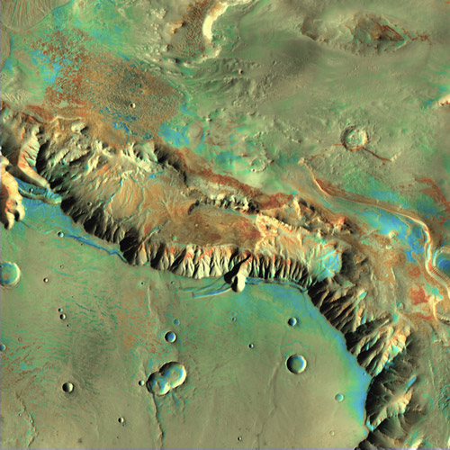 This color image shows a plateau above high cliff walls spewing aprons of debris into a basin.
