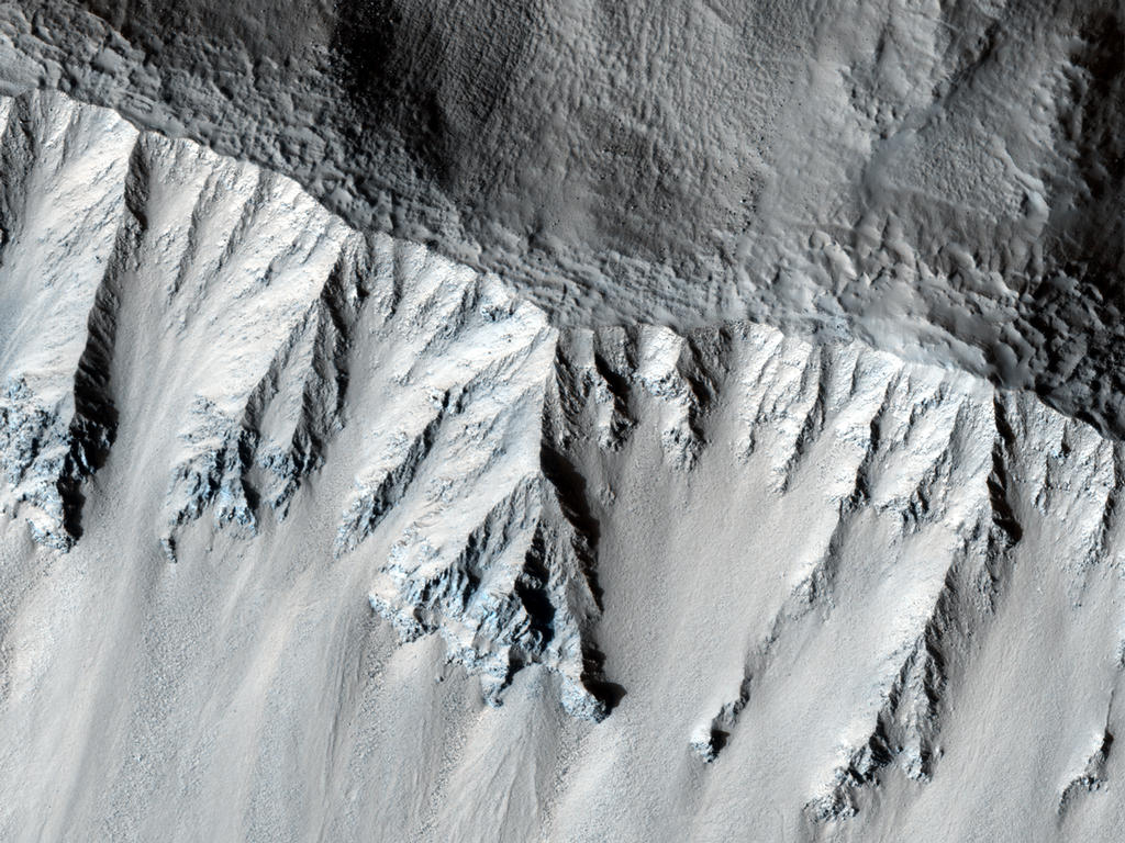 This fresh crater is located in the northern mid-latitudes. It is designated as fresh because of its very sharp rim.

The crater has experienced some modification since it formed, including a few tiny craters on the south wall.

The rough texture of the floor is suggestive of ground ice, which is expected to exist in the mid-latitudes. Ground ice aids gravity in moving material from the crater walls towards the center. Material is visible slumping off the northwest crater wall in this fashion. The wavy texture of the center of the crater floor suggests that material has been transported from the walls and merged in the center.